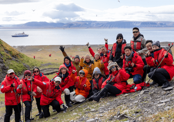 Kreuzfahrtgäste winken auf Spitzbergen bei der Anlandung in die Kamera